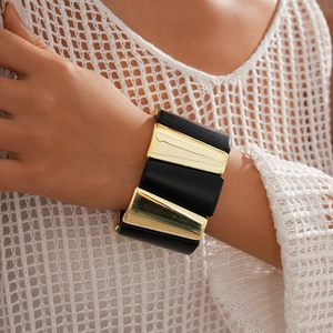 Close-up of geometric black and gold acrylic segmented bracelet on model wrist