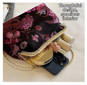 Detail of floral embroidery evening bag showing spacious interior for phone and cosmetics