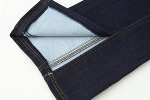 Gros plan détaillé d'une veste en jean bleu foncé avec coutures contrastées dorées