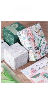 Detailed close-up of jungle animal pattern wrapping paper on a gift box with a pink cotton cord