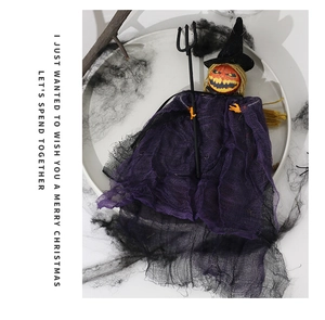 Detail of hanging Halloween pumpkin witch ghost with purple mesh cloak and black trident