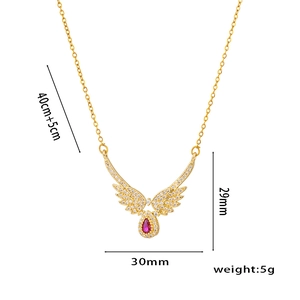 Gold angel wing necklace with ruby teardrop pendant and crystal pavé details
