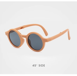Detailed 45-degree side view of foldable beige round frame children's sunglasses