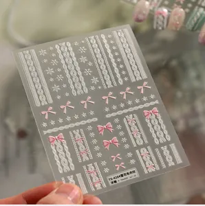 Detailed 5D embossed nail stickers featuring white sweater patterns and pink bows