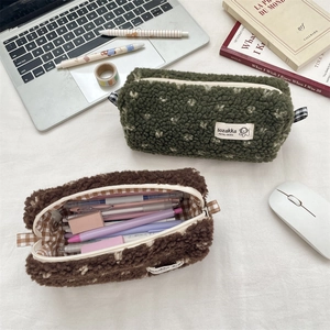 Vue détaillée de la trousse en peluche montrant la grande capacité et la doublure à carreaux