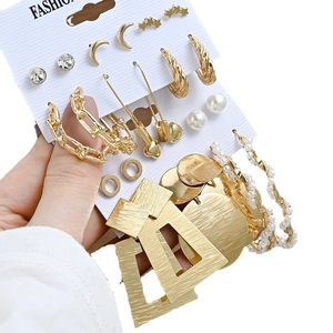Set of gold geometric earrings with pearls and rhinestones on a white display card