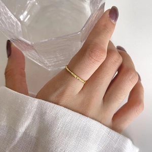 Minimalist 925 sterling silver ring with irregular gold wave texture on a finger