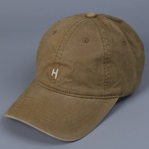 Close-up of khaki washed cotton baseball cap with white H letter embroidery detail