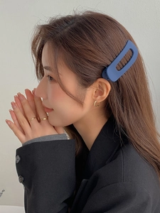 Side view of matte blue square cutout hair clip worn by model for elegant styling