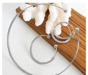 Detailed view of woven mesh texture on silver jewelry set with necklace and earrings