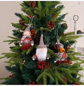 Hanging Christmas plush ornaments featuring Santa, reindeer, and gnome on a festive tree