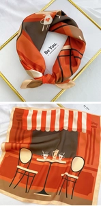 Detail of square silk scarf showing cafe print and decorative knotting style