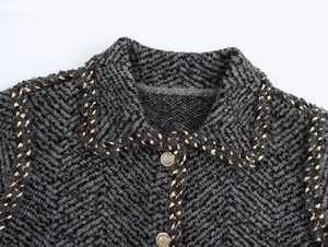 Detailed view of grey herringbone knit cardigan texture and gold heraldic metal buttons