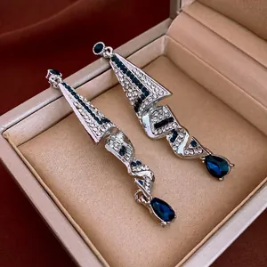 Elegant geometric spiral silver earrings with blue teardrop crystals and pavé diamonds