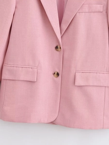 Detail view of pink blazer featuring single-breasted buttons and flap pockets