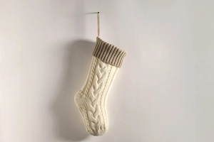 Close-up of beige and light brown knit Christmas stocking with detailed cable stitch patterns