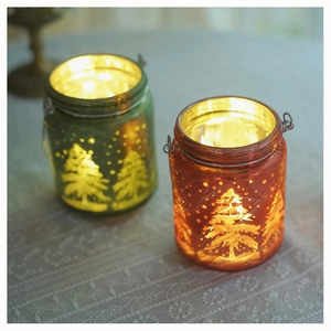 Detail of red and green frosted glass Christmas lanterns with tree and snowflake patterns