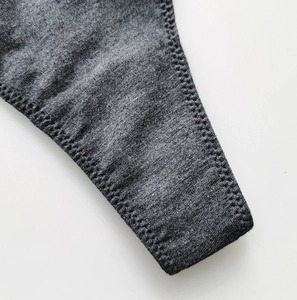 Close-up of gray cotton knit fabric texture and durable stitching on thong side band