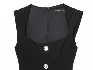 Detail of square neckline with luxury rhinestone buttons on a black sleeveless jumpsuit