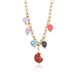 Gothic gold link necklace with colorful skull charms and a red snail pendant on white back