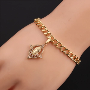 Detail of gold-plated Virgin Mary charm bracelet with cubic zirconia on a model