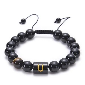 Detail of adjustable black agate bead bracelet featuring a gold letter U on black bead