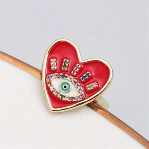 Detail of gold heart ring with red enamel devil eye and colorful zircon inlay