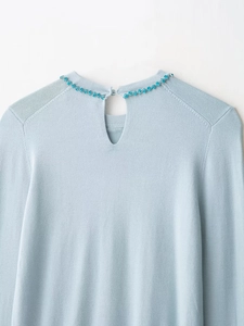 Detail of light blue knit sweater with rhinestone collar and keyhole back closure