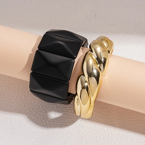 Textured gold twist bangle and matte black geometric pyramid stud cuff bracelet set