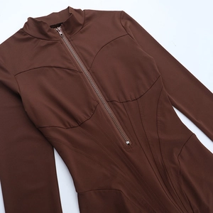 Detail of a brown slim fit jumpsuit featuring structured stitching and a front zipper closure