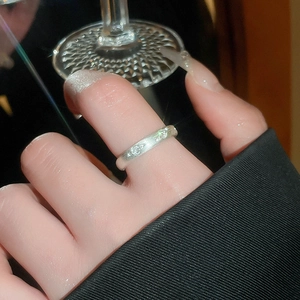 Detail of silver wavy geometric ring with matte finish and sparkling crystals on hand