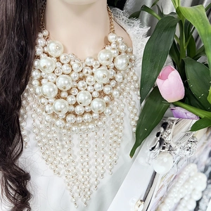 Statement layered white pearl bib necklace with long tassels on a model for bridal style