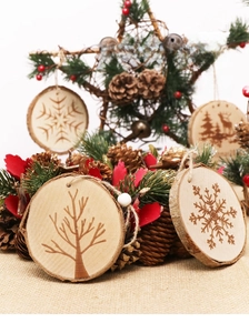Detail of wooden Christmas tree ornaments with laser-engraved deer and snowflake patterns