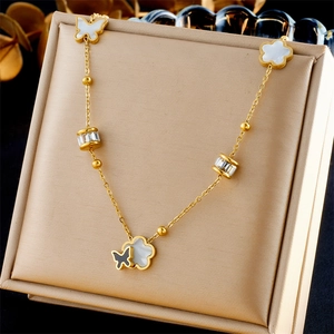 Detailed view of gold butterfly and white floral pendant necklace in a gift box