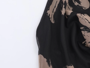 Detailed close-up of stretchy mesh fabric featuring a black and beige abstract floral print