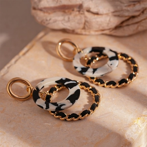 Detail of vintage leopard resin earrings featuring woven gold metal and marble texture