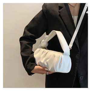 Detail of white pleated cloud bag with knotted handle and detachable shoulder strap