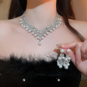 Détail d'un ensemble de bijoux de mariée de luxe avec strass et perles porté par un modèle