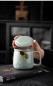 Macro shot of celadon ceramic mug showing intricate ice-crackle glaze and floral pattern