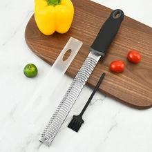 Stainless steel grater with black handle and protective cover on wooden board