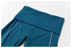 Détail du pantalon de yoga taille haute bleu sarcelle avec bandes latérales blanches