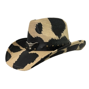 Detail of western cow print straw hat featuring a leather band with metal bull head emblem