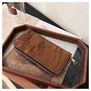 Detailed macro of brown Tyvek texture and golden metal zipper on a long wallet
