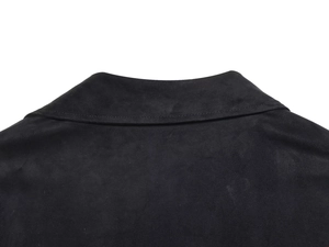 Gros plan détaillé des coutures et de la texture suédée sur le col de la chemise noire