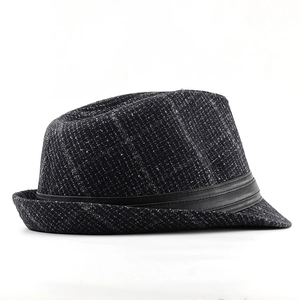 Close-up of vintage tweed jazz hat with dark grey textured fabric and black leather band