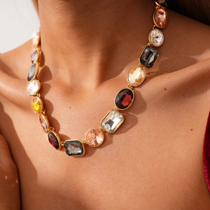 Detail of multi-color crystal necklace with geometric shapes and golden finish on model