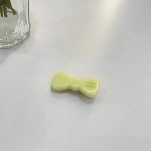 Close-up of a yellow jelly-textured handmade bow hair clip with France Handmade engraving