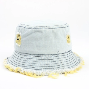 Dettaglio cappello pescatore denim azzurro con bordi sfrangiati gialli e strappi retrò