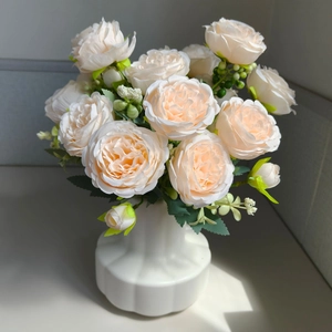 Detail of faux pink roses in a white ceramic pumpkin vase for home decor setup