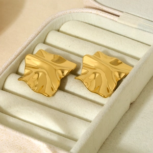 Detail showing gold 316L stainless steel wrinkled geometric earrings in a jewelry box